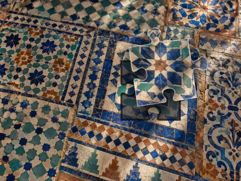 Handmade geometric tiles in cobalt, teal, cream and terracotta with worn grout and glossy glaze.