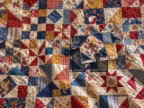 Handmade patchwork quilt combining floral, checked, striped and dotted cotton fabrics.